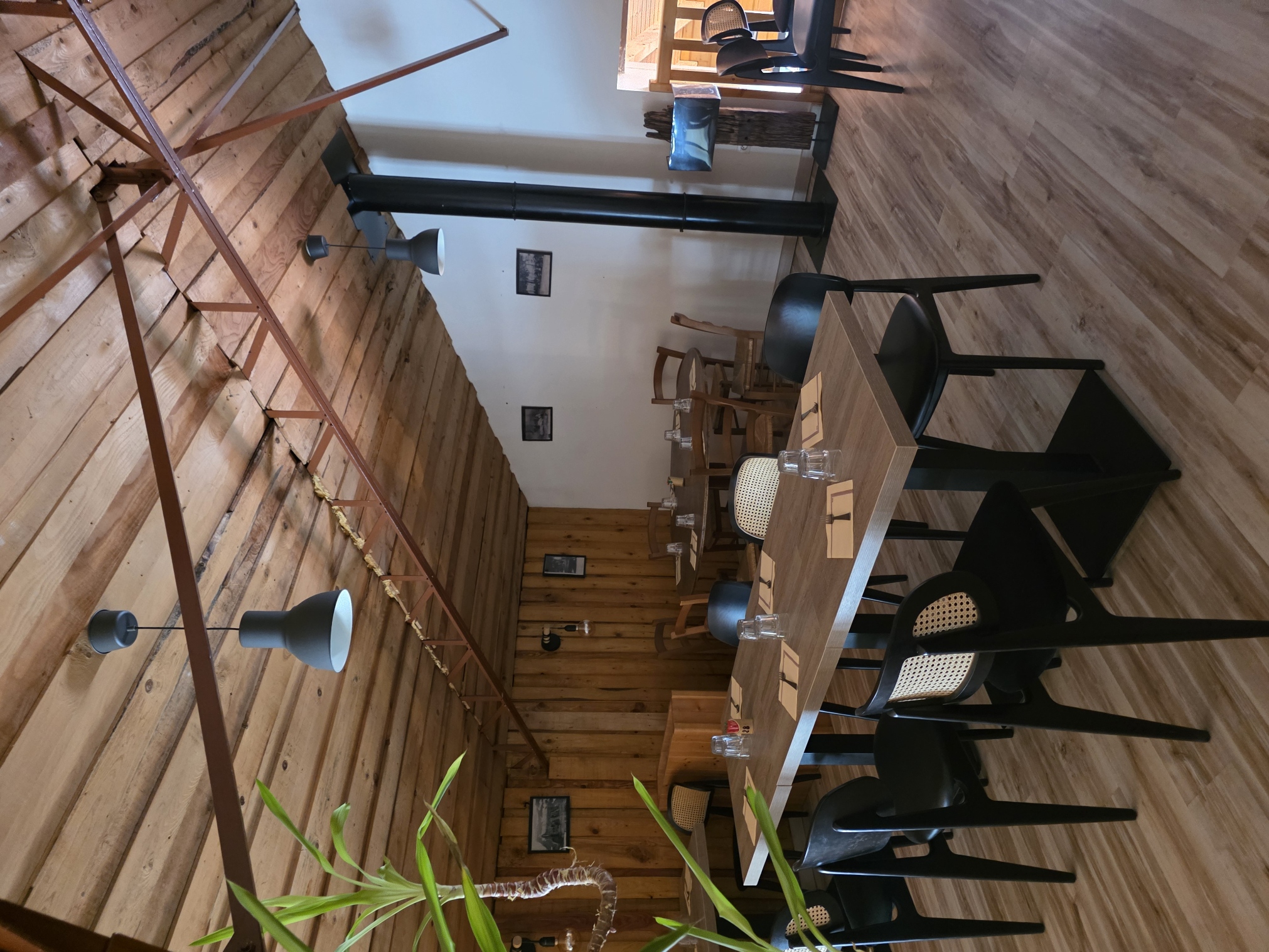 La salle du restaurant, ses tables et son plafond en bois